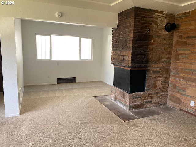 unfurnished living room featuring visible vents, baseboards, and carpet flooring