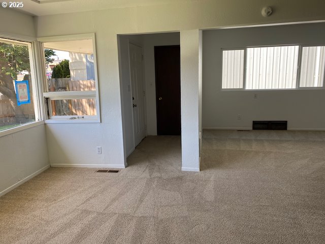 carpeted spare room with baseboards and visible vents