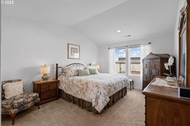 bedroom with light colored carpet, vaulted ceiling, and visible vents