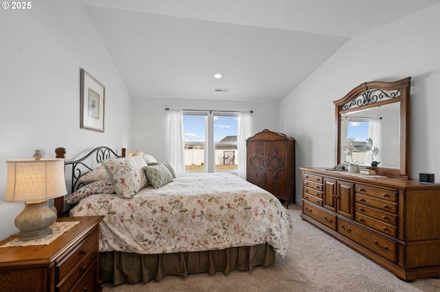 bedroom featuring lofted ceiling, visible vents, and light carpet