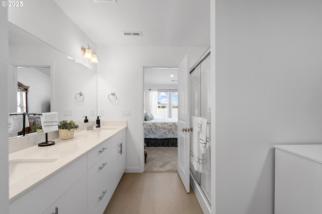ensuite bathroom with double vanity, visible vents, a sink, connected bathroom, and a stall shower