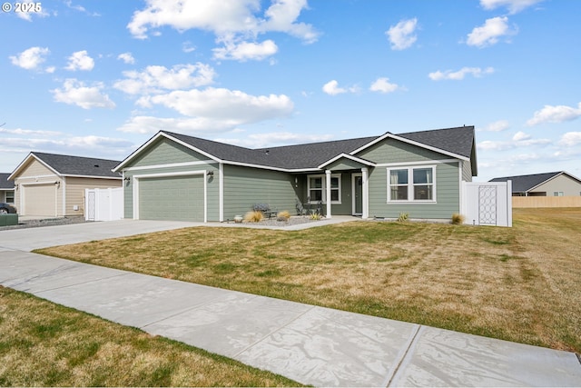 ranch-style home with concrete driveway, a front lawn, fence, and a garage