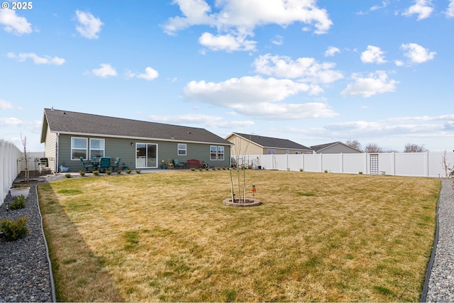 back of house featuring a patio area, a lawn, and a fenced backyard