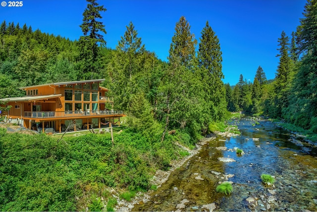 exterior space with a forest view and dirt driveway