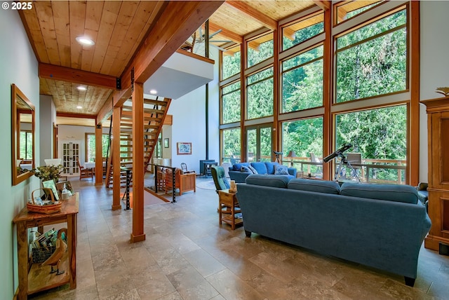 living room with beamed ceiling, recessed lighting, a high ceiling, wooden ceiling, and stairs