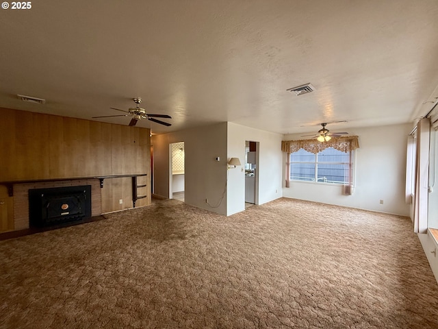 unfurnished living room featuring ceiling fan, carpet floors, and a fireplace