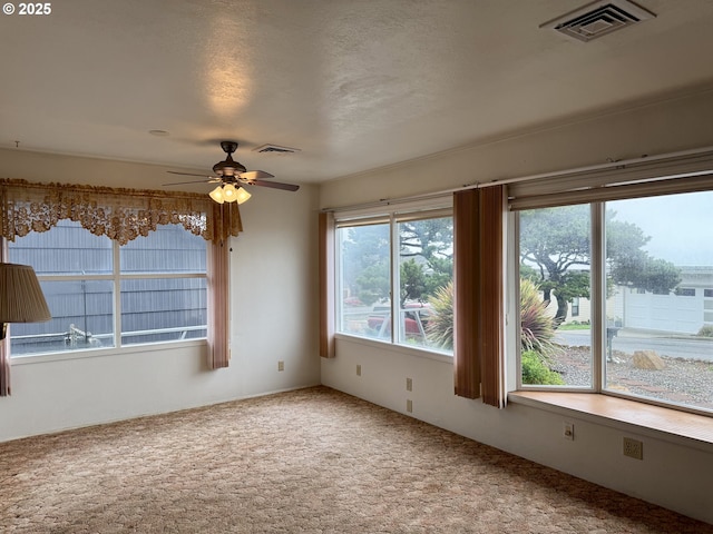 carpeted empty room featuring a textured ceiling and ceiling fan