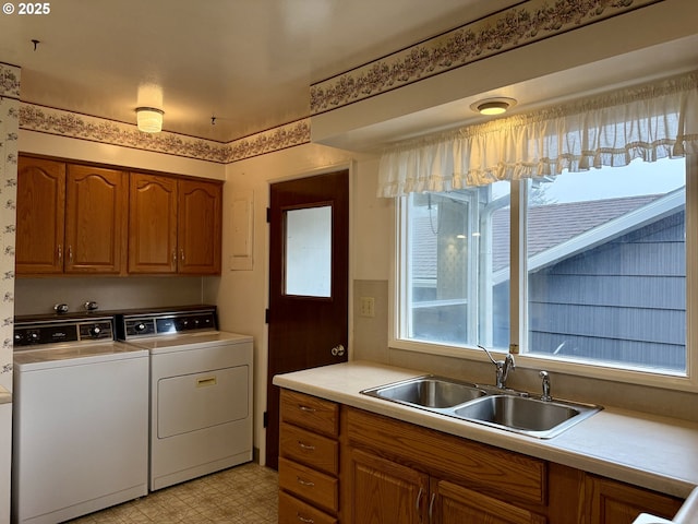 washroom with cabinets, washer and clothes dryer, and sink