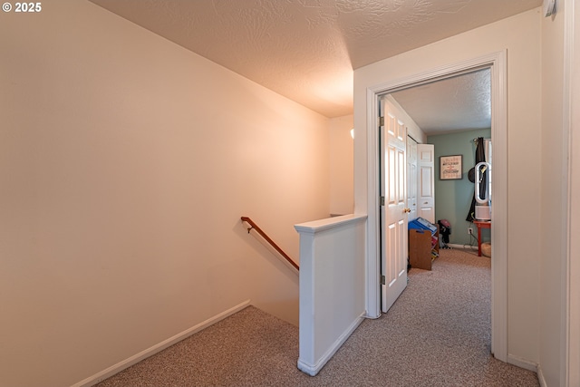 corridor featuring carpet and a textured ceiling