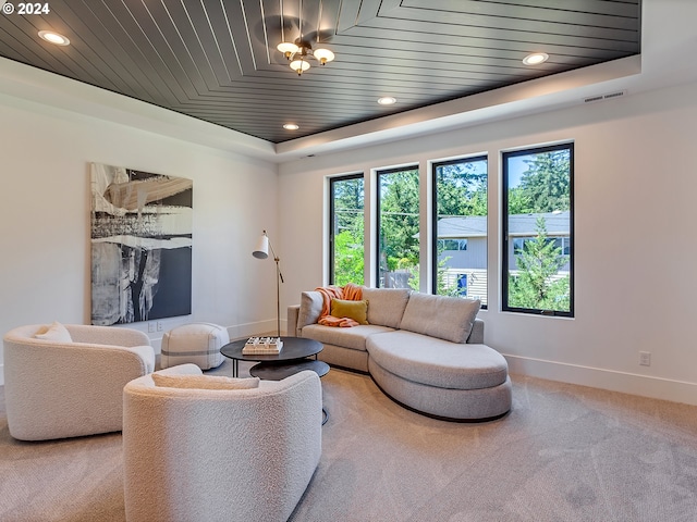 living room featuring carpet floors, a raised ceiling, and wood ceiling