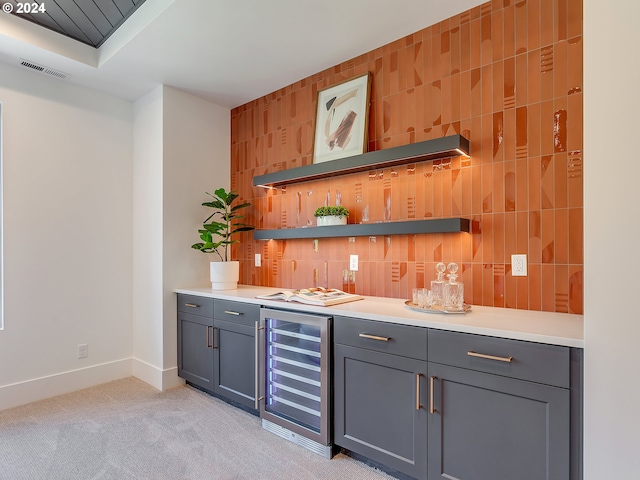 bar featuring gray cabinetry, light colored carpet, and wine cooler