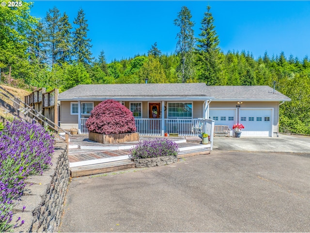 946 E 9th Pl, Coquille, OR 97423 - single story home featuring an attached garage, a porch, asphalt driveway, and a forest view