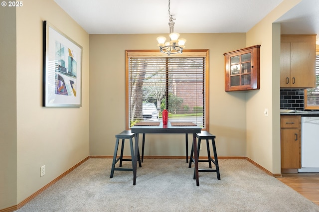 dining area featuring light colored carpet and a chandelier