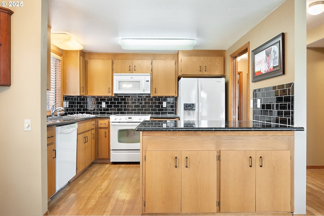 kitchen with tasteful backsplash, white appliances, light hardwood / wood-style flooring, and dark stone counters