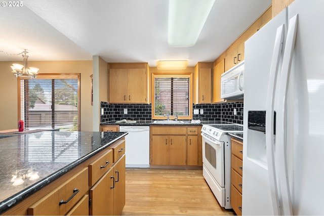 kitchen with sink, white appliances, light hardwood / wood-style flooring, tasteful backsplash, and a healthy amount of sunlight