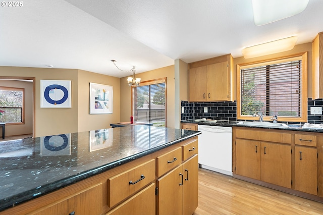 kitchen featuring sink, tasteful backsplash, a chandelier, white dishwasher, and light hardwood / wood-style floors