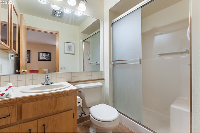 bathroom featuring vanity, backsplash, toilet, and walk in shower