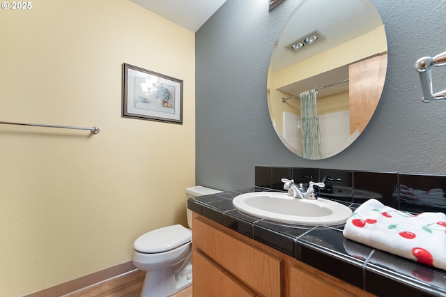 bathroom with vanity, hardwood / wood-style floors, walk in shower, and toilet