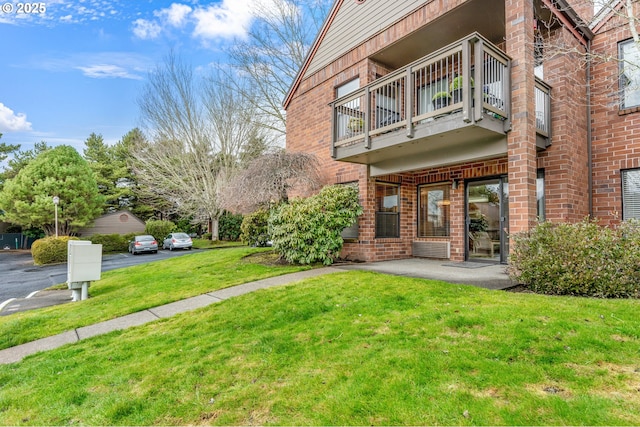 exterior space featuring a lawn and a balcony