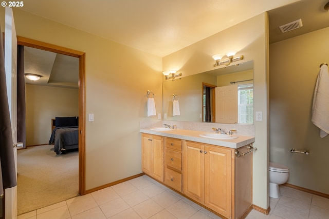 61 SW Wallingford Way, Beaverton, OR 97006 - ensuite bathroom with double vanity, tile patterned flooring, toilet, and baseboards