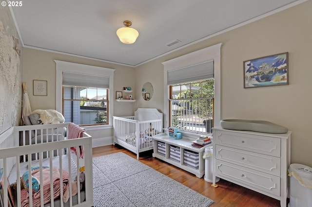 3701 NE Davis St, Portland, OR 97232 - bedroom with multiple windows, crown molding, dark wood finished floors, and a nursery area