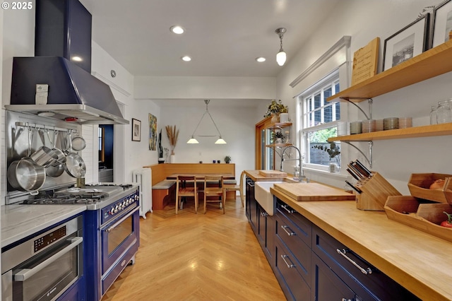 3701 NE Davis St, Portland, OR 97232 - kitchen featuring wood counters, extractor fan, appliances with stainless steel finishes, blue cabinetry, and open shelves