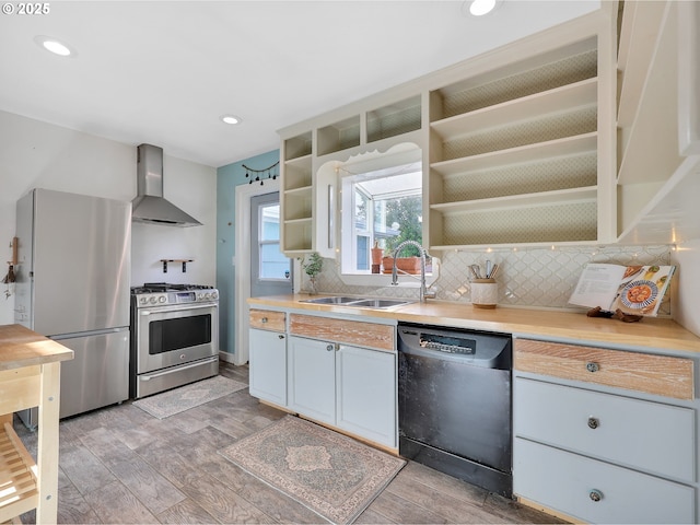 1466 8th St, Astoria, OR 97103 - kitchen featuring stainless steel appliances, wall chimney range hood, open shelves, light wood-style flooring, and tasteful backsplash