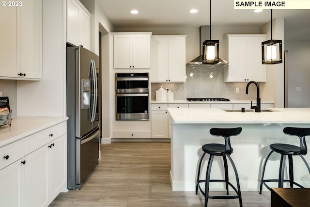 352 S 88th Ave, Ridgefield, WA 98642 - kitchen with stainless steel appliances, ventilation hood, a breakfast bar area, tasteful backsplash, and white cabinets