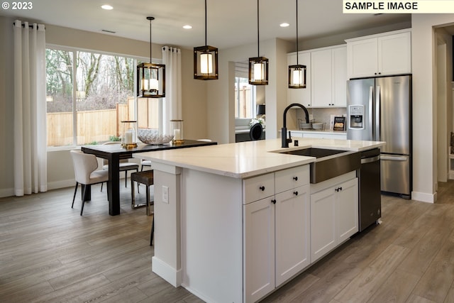 352 S 88th Ave, Ridgefield, WA 98642 - kitchen with stainless steel appliances, recessed lighting, light wood-style flooring, a kitchen island with sink, and light stone counters