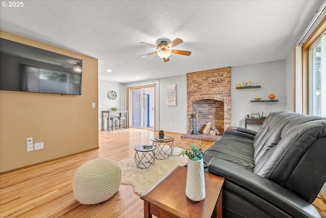 2130 SW 195th Ave, Beaverton, OR 97003 - living area with a ceiling fan, wood finished floors, a textured ceiling, and a fireplace