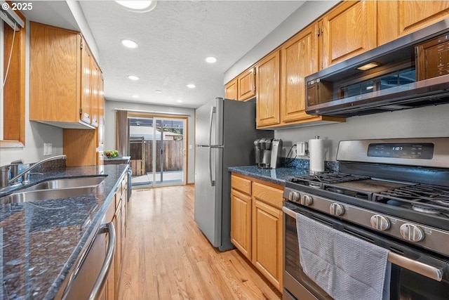 2130 SW 195th Ave, Beaverton, OR 97003 - kitchen with appliances with stainless steel finishes, light wood-type flooring, recessed lighting, dark stone counters, and brown cabinetry