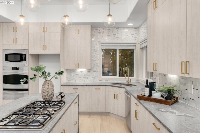 kitchen with tasteful backsplash, light hardwood / wood-style floors, appliances with stainless steel finishes, and light stone counters