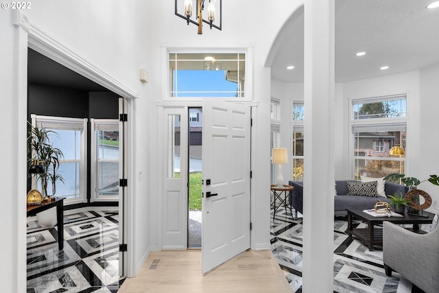 foyer entrance with a notable chandelier and light hardwood / wood-style flooring