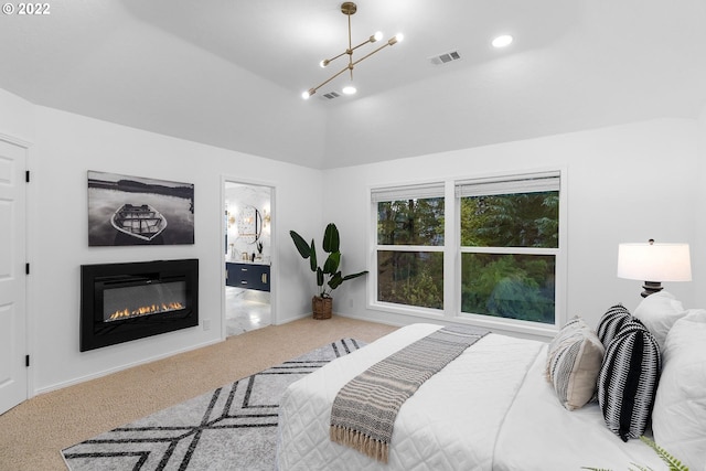 carpeted bedroom with a chandelier and vaulted ceiling