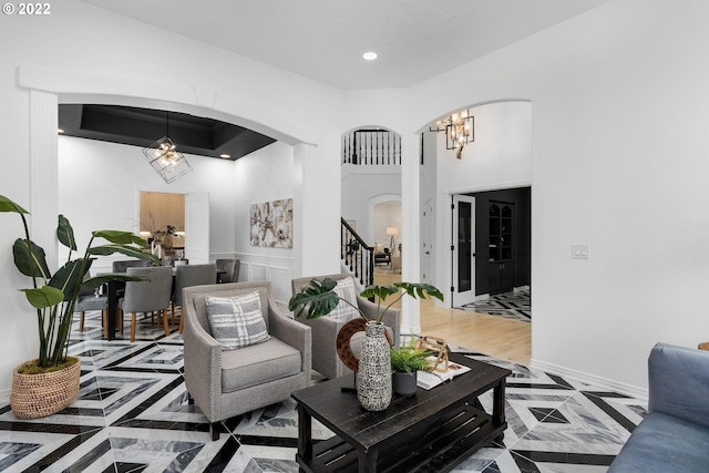 living room with a chandelier, dark wood-type flooring, and a towering ceiling