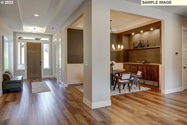 entrance foyer featuring light hardwood / wood-style flooring and a notable chandelier