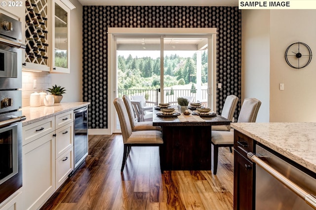 dining area featuring beverage cooler and dark hardwood / wood-style flooring