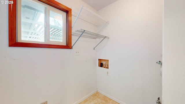 laundry area with laundry area, baseboards, and washer hookup