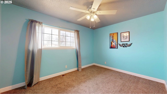 carpeted spare room with visible vents, baseboards, a textured ceiling, and a ceiling fan