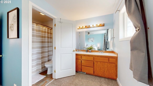 full bathroom featuring double vanity, curtained shower, toilet, and a sink