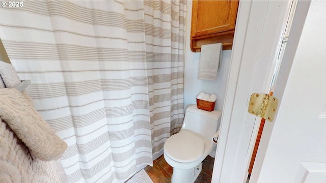 full bath featuring curtained shower, toilet, and wood finished floors