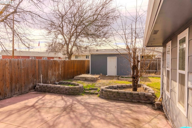 view of patio with an outbuilding and a fenced backyard