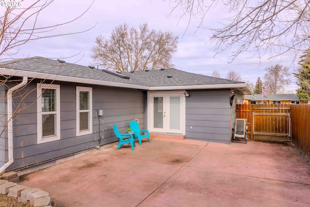 back of house featuring a patio area, french doors, roof with shingles, and fence