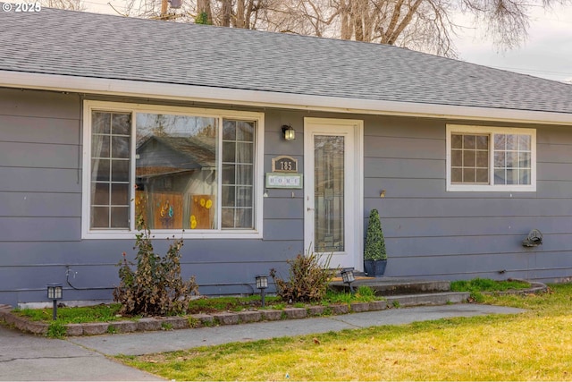 property entrance featuring roof with shingles