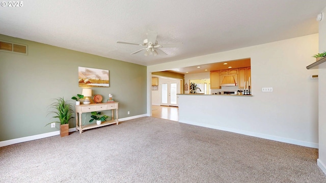 unfurnished living room featuring visible vents, baseboards, light carpet, french doors, and a ceiling fan