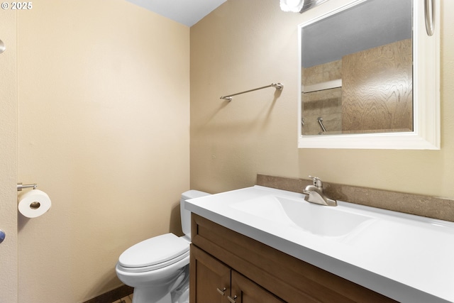 bathroom with toilet, vanity, and a shower