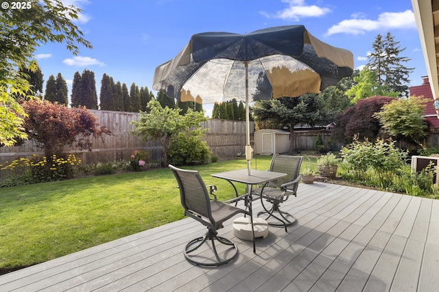 wooden deck featuring a storage shed, an outbuilding, and outdoor dining space