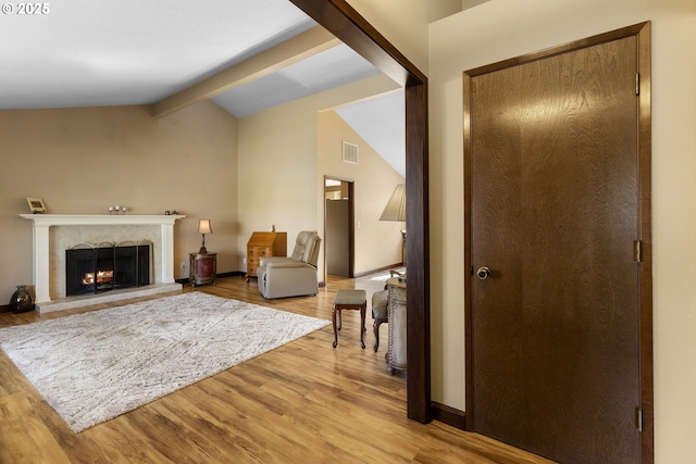 living area featuring light wood-type flooring and a premium fireplace