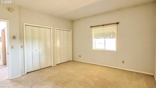 36582 Valley View Ln, Halfway, OR 97834 - unfurnished bedroom featuring two closets, baseboards, and light colored carpet