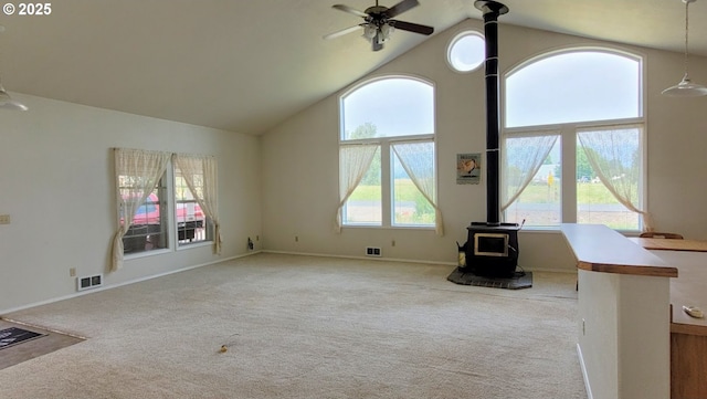 36582 Valley View Ln, Halfway, OR 97834 - unfurnished living room with a wood stove, high vaulted ceiling, carpet, a ceiling fan, and visible vents